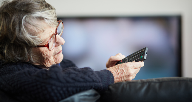 A woman holding TV remote control