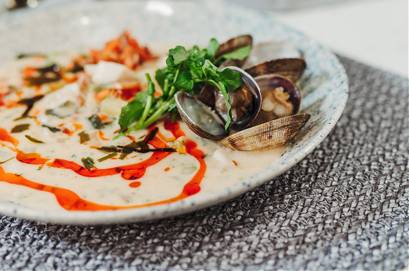 A shallow bowl of seafood chowder.