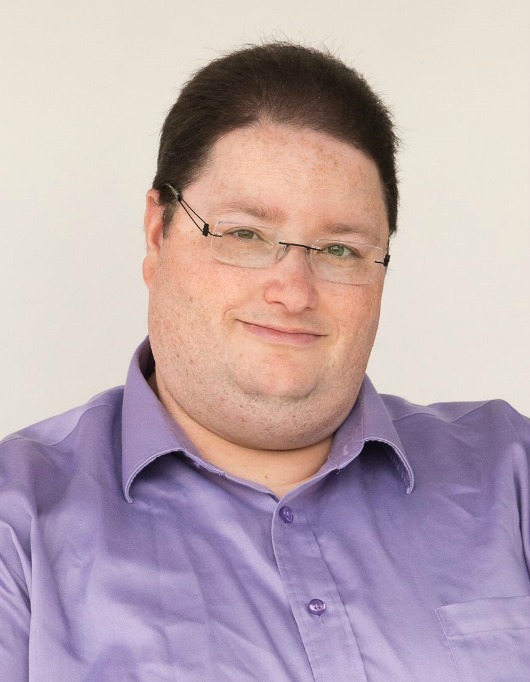 A man smiles into the camera.