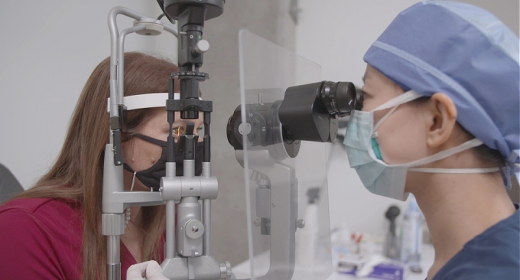 An eye doctor performs and eye exam.